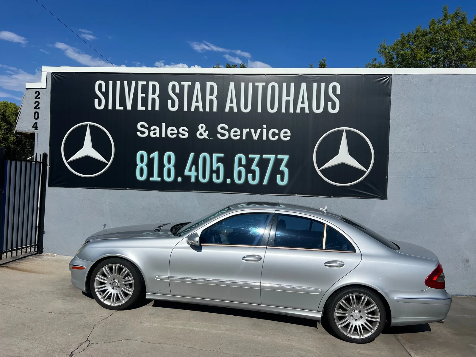 Silver Mercedes-Benz sedan parked in front of Silver Star Autohaus sign at 2204 W Burbank Blvd, Burbank